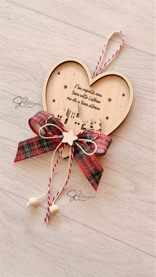 Decorazione natalizia cuore in legno con frase incisa e fiocco scozzese. Un addobbo artigianale unico, ideale per albero e regali di Natale.
